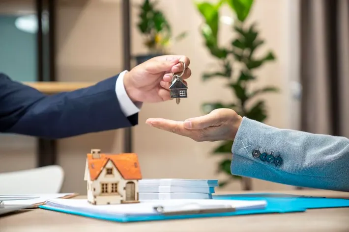 Real estate agent handing over house keys to a buyer.